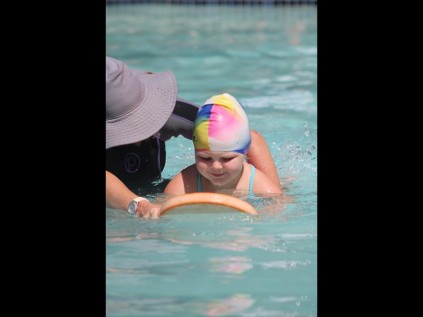 Fish Eagles Club coach Bronwyn MacDonald gives little Talia Linde some handy tips