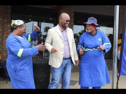 Minister of Police Nathi Mthethwa enjoying a 'Jika' with municipal workers Mirriam Mahlangu and Tholakhele Mthethwa