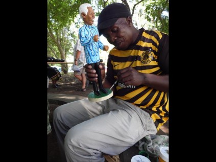 Wood-carver Bhekhi Gumbi completes his latest Nelson Mandela piece. Each of his carvings takes five days to complete. He uses wood from the Amarula tree