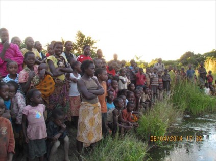 Onlookers at the baptism in the village