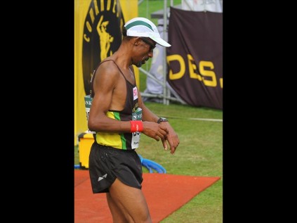 Checking his watch at 7.38.52 is first uMhlathuze Athletics Club runner over the line, Willie Shabalala PHOTO: Larry Bentley