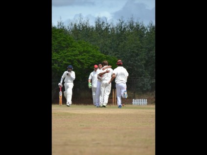 Village players celebrate after claiming the scalp of Schools XI opening batsman Addullah Mahomed, who scored 23 runs