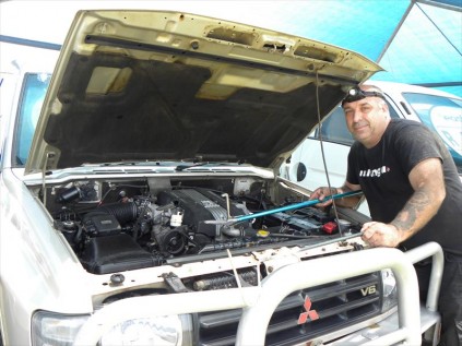 Wayne "Beastman" Rawlinson shows the spot where the olive grass snake was seen before it dissapeared further into the engine bay