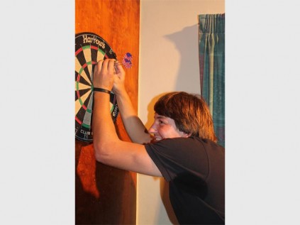 Little Portugal's Willie van Rooyen collects his darts after putting 60 points on the board PHOTOS: RICHARD SPRINGORUM