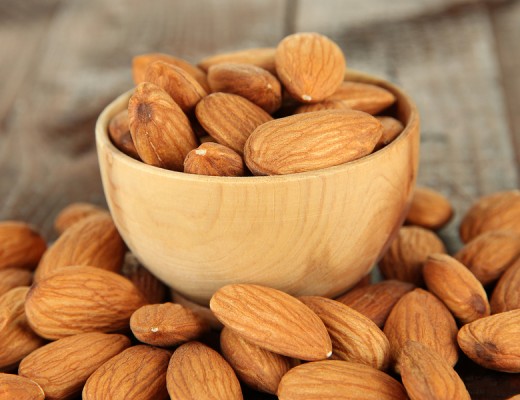 Almond in wooden bowl, on wooden background