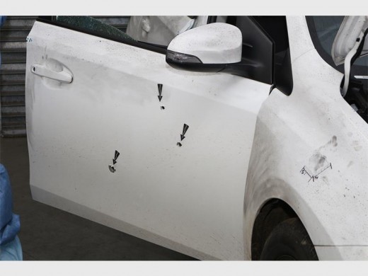 Three bullet holes in the front door and one through the rear window are proof that the policemen involved bravely faced their attackers