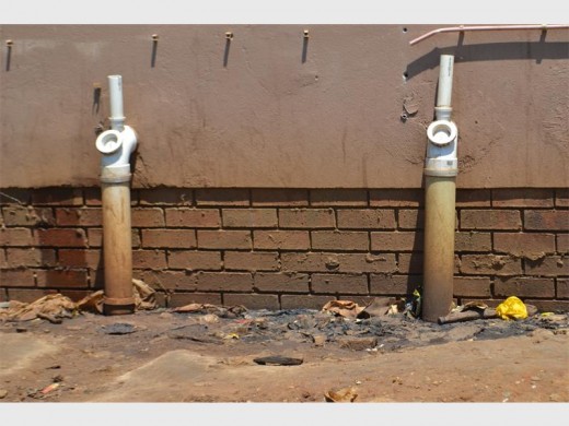 With the new ablution facilities remaining locked, male commuters use the outside wall to relieve themselves
