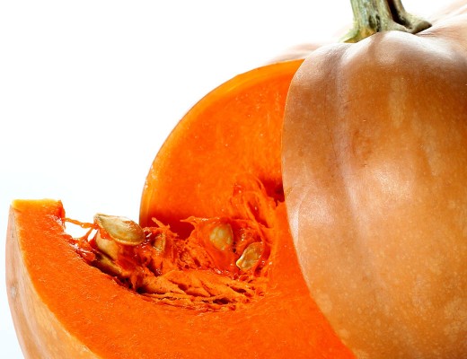 pumpkin with cut pieces on white background