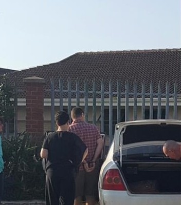 Johan Nepgen in cuffs and supported by Helena, at the Richards Bay police station following his arrest  in February