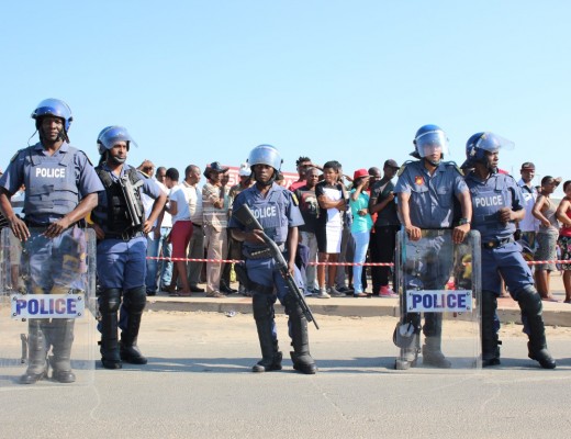 Police armed with shotguns and rubber bullets form a line between ANC and EFF supporters