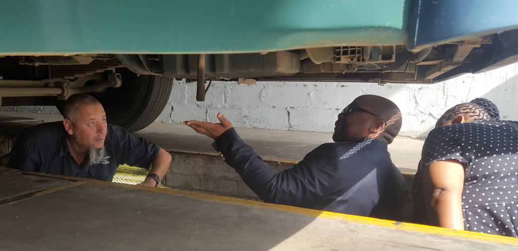 Richards Bay Vehicle Test Centre co-owner Neville Tarin shows the Mayor how to inspect a bus from the bottom up