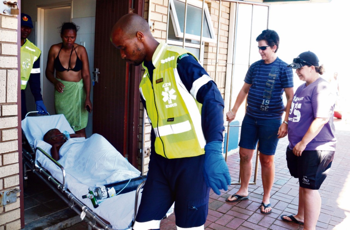 As a concerned family member looks on, EMRS medics MG Mdimande and SF Mashazi carry little Junior Khanyi from the lifeguard house to the waiting ambulance. Also at the scene were drown rescuers Cicilija Botha and Bernice Cannon