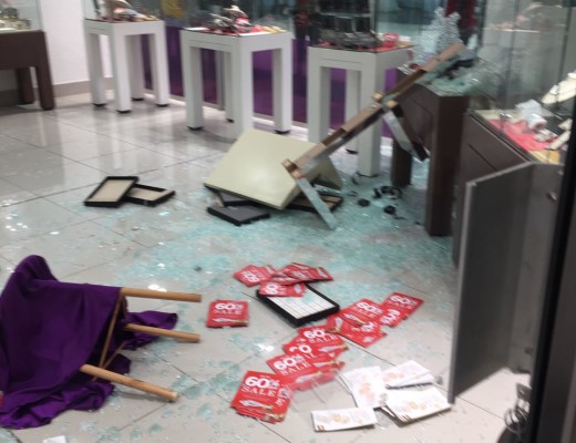 Onlookers try to get a glimpse of the damage caused to the store