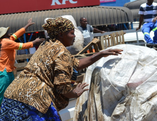 MaZulu and municipal employees carry loads of her belongings to a municipal vehicle
